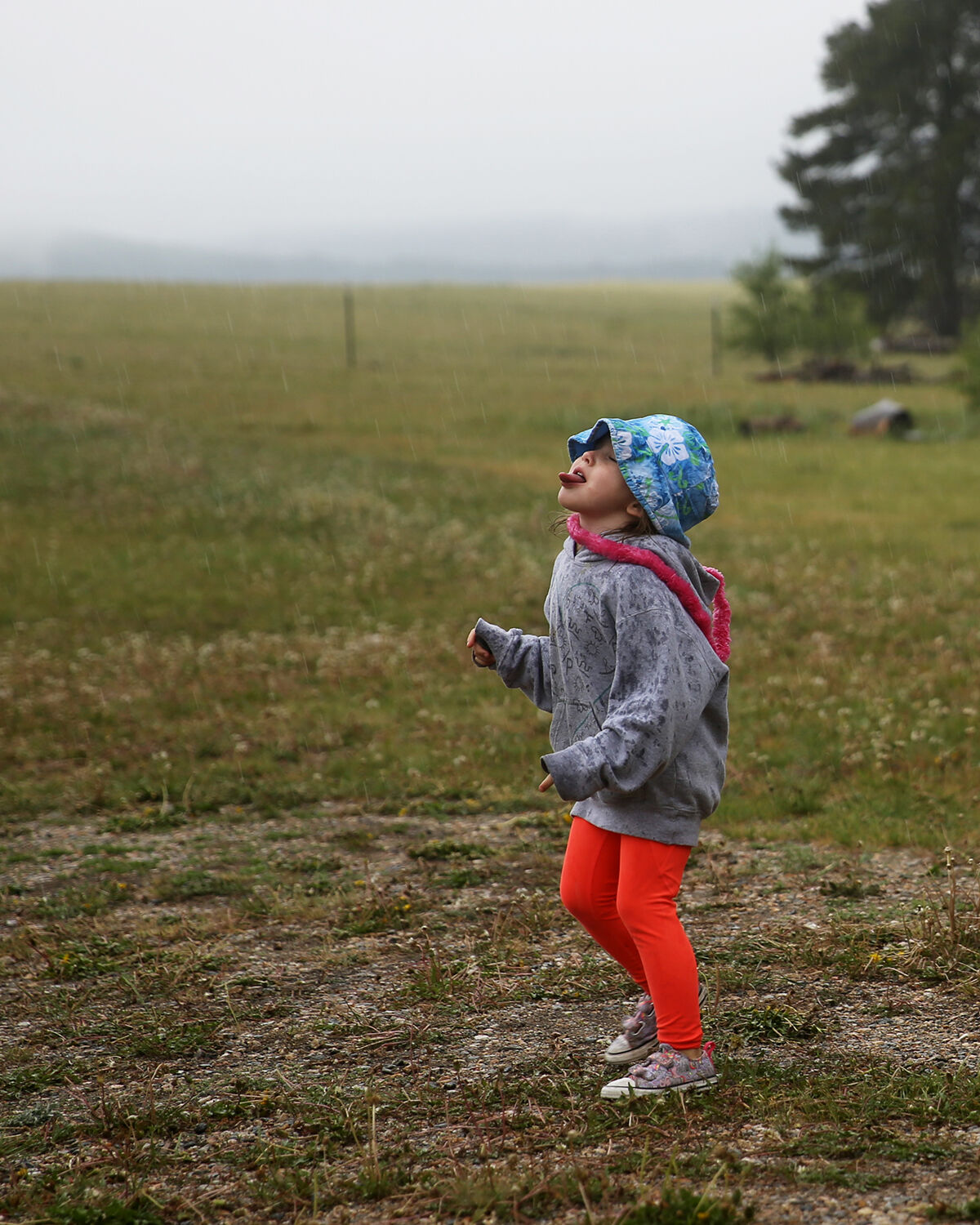 Gracy Alger spins in the rain, catching water droplets on her tongue
